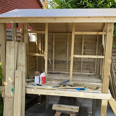 a wooden shed with a bench and tools on it