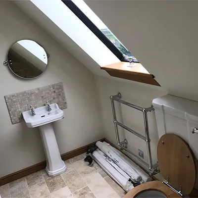 a bathroom with a toilet, sink, and mirror