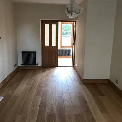 an empty room with a wooden floor and a door